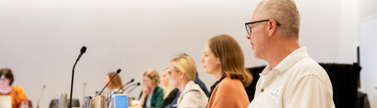 Group of people seated at a meeting watching a presentation