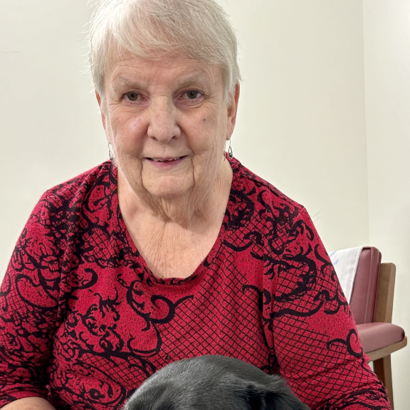 Smiling woman with white hair in a red and black top