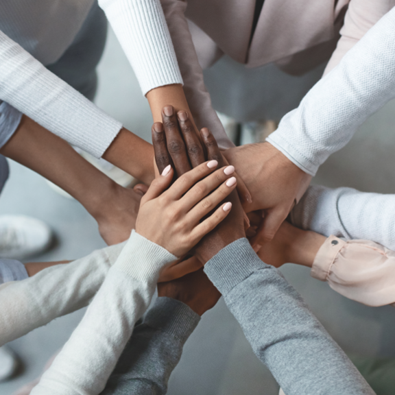 hands of different skin colours joining together
