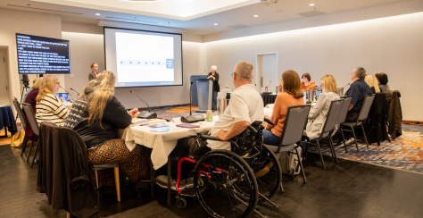 Group of people seated at a meeting watching a presentation